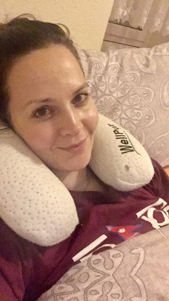 Krank im Bett mit Nackenkissen